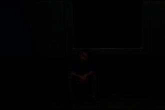 Egy férfi ül a sötétben, a szakítás fájdalmának hívószava.