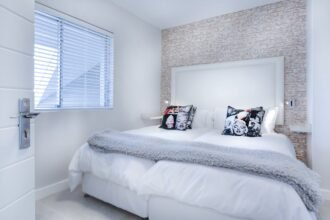 Tiszta és stílusos hálószoba ágyneművel és dekoratív párnákkal.