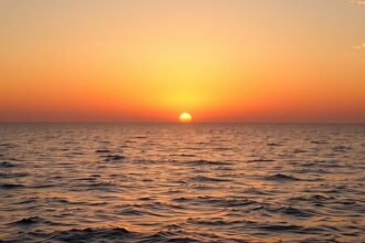 Naplemente a tenger felett, nyugodt vízfelület