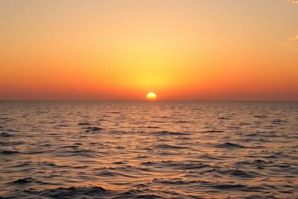 Naplemente a tenger felett, nyugodt vízfelület