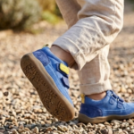 Gyerek mezítlábas cipő köves úton, felfedezés közben.