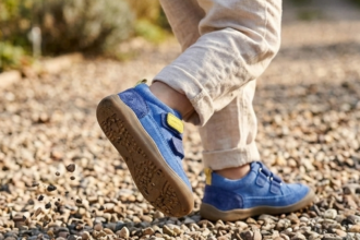 Gyerek mezítlábas cipő köves úton, felfedezés közben.