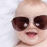 Boldog baba napszemüvegben, biztonságos napsugárzás ellen.