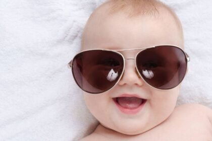 Boldog baba napszemüvegben, biztonságos napsugárzás ellen.