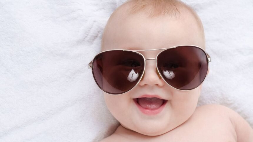 Boldog baba napszemüvegben, biztonságos napsugárzás ellen.