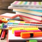 Színes irodai kellékek, post-it jegyzetek és füzetek egy asztalon