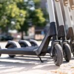 Elektromos roller parkolóban, zöld fákkal körülvéve